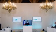 French President Emmanuel Macron, tested positive for the coronavirus disease (COVID-19), is seen on a screen as he attends by video conference a round table for the National Humanitarian Conference (NHC) at the Foreign Ministry in Paris on December 17, 2