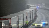 Police officers speak to a driver in one of lorries parked on the M20 motorway towards Eurotunnel and the Port of Dover, as EU countries impose a travel ban from the UK following the coronavirus disease (COVID-19) outbreak, in Folkestone, Britain, Decembe