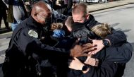 Nashville Metro Police Chief John Drake (L) and officers Amanda Topping, Michael Sipos, James Luellen, Brenna Hosey, and James Wells embrace after a news conference held to discuss the Christmas Day motor home explosion in Nashville, Tennessee, U.S. Decem