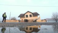 A policeman stands in front of a damaged house in Prokopa village after an earthquake in Croatia, December 30, 2020. REUTERS/Antonio Bronic