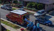 County of Los Angeles paramedics examine a potential Covid-19 patient sitting on the sidewalk before transporting him to a hospital in Hawthorne, California on December 29, 2020.  AFP / Apu GOMES