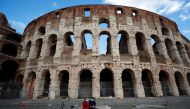 People wearing protective face masks sit near the Colosseum, one day before the country goes back to lockdown as part of the efforts put in place to curb the spread of the coronavirus disease (Covid-19), in Rome, Italy, January 4, 2021. Reuters/Guglielmo 