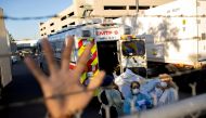 FILE PHOTO: An El Paso County Sheriff's Officer tries to block photographs from being taken as bodies are moved to refrigerated trailers, deployed during a surge of coronavirus disease (COVID-19) deaths, outside the County of El Paso Medical Examiner's Of