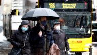 People wear face masks as they walk past a bus during lockdown due to the coronavirus disease (COVID-19) pandemic in Berlin, Germany, January 19, 2021. REUTERS/Fabrizio Bensch
