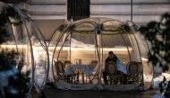 FILE PHOTO: A man sits in a bubble tent as the spread of the coronavirus disease (COVID-19) continues, in New York City, New York, U.S., February 4, 2021. REUTERS/Jeenah Moon/File Photo
