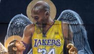 FILE PHOTO: A fan poses by a mural of late Kobe Bryant, who perished one year ago alongside his daughter and seven others when their helicopter crashed into a hillside, in Los Angeles, California, U.S., January 26, 2021. REUTERS/Mario Anzuoni/File Photo
