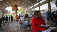 People wait before a healthcare worker takes a sample for the COVID-19 rapid antigen testing, at the Iztapalapa neighbourhood in Mexico City, Mexico, February 5, 2021. REUTERS/Henry Romero
