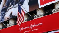 FILE PHOTO: The U.S. flag is seen over the company logo for Johnson & Johnson to celebrate the 75th anniversary of the company's listing at the New York Stock Exchange (NYSE) in New York, U.S., September 17, 2019. REUTERS/Brendan McDermid/File Photo
