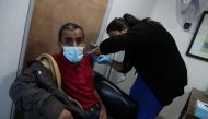 A homeless man receives a dose of Sinovac's CoronaVac coronavirus disease (COVID-19) vaccine during a vaccination campaign for homeless people, in Santiago, Chile March 26, 2021. REUTERS/Ivan Alvarado
