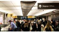 Travelers wearing protective face masks to prevent the spread of the coronavirus disease (COVID-19) reclaim their luggage at the airport in Denver, Colorado, U.S., November 24, 2020. REUTERS/Kevin Mohatt/File Photo