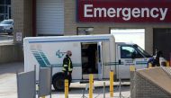 FILE PHOTO: A health care worker in a surgical mask helps unload a stretcher service vehicle at St. Boniface Hospital, which is a reported site of the coronavirus disease (COVID-19) outbreak according to local media, in Winnipeg, Manitoba, Canada, Novembe