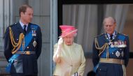 Britain's Queen Elizabeth waves as she stands with Prince William (L) and Prince Philip as they prepare to view a RAF flypast to mark the 75th anniversary of the Battle of Britain, from the balcony of Buckingham Palace in London, Britain July 10, 2015. RE