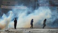 Supporters of the Tehreek-e-Labaik Pakistan (TLP) Islamist political party run to cover amid the smoke of tear gas fired by police during a protest against the arrest of their leader in Lahore, Pakistan April 13, 2021. REUTERS/Stringer
