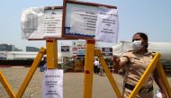 A policewoman gestures past notices about the shortage of vaccine for the coronavirus disease (COVID-19) at a vaccination centre in Mumbai, India, April 28, 2021. REUTERS/Niharika Kulkarni
