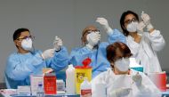 Health workers prepare doses of the Pfizer-BioNTech COVID-19 vaccine at an inoculation centre in Naples, Italy, January 8, 2021. REUTERS/Ciro De Luca/File Photo
