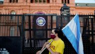 FILE PHOTO: FILE PHOTO: A demonstrator holds an Argentinian flag as they protest against Argentina's President Alberto Fernandez's lockdown measures to curb the spread of the coronavirus (COVID-19) disease, outside Casa Rosada presidential palace in Bueno
