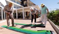 Residents Paul Souveton, Bernard Sellier and Frederique Benichou play mini golf at 