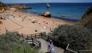 A person leaves Dona Ana beach in Lagos, Portugal, June 3, 2021. REUTERS/Pedro Nunes