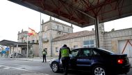 FILE PHOTO/A Spanish police officer checks a car at the border between Portugal and Spain,REUTERS