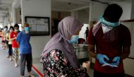 Residents of a public housing estate queue up for mandatory coronavirus disease (COVID-19) swab tests in Singapore May 21, 2021. REUTERS/Edgar Su/File Photo