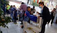 A child receives hand sanitizer while arriving at the Ignacio Zaragoza elementary school. (Reuters/Luis Cortes/File Photo)