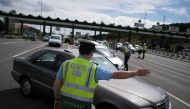 A police officer stops a car at a checkpoint for control to stop unauthorised travel during a two-day weekend from and to Lisbon's metropolitan area, to contain the spread of the coronavirus disease (COVID-19) as the number of cases rise, in Alverca, Port