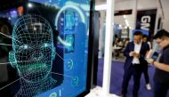 Visitors check their phones behind the screens advertising facial recognition software during Global Mobile Internet Conference at the National Convention in Beijing, China April 27, 2018. Reuters/Damir Sagolj/File Photo