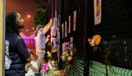 People hang up more signs of missing residents and light candles from the partial collapse in Surfside where the rescue personnel continue their search for victims the day after in Surfside near Miami Beach, Florida, U.S., June 25, 2021. (Reuters/Maria Al