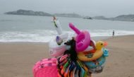 A float seller walks in Acapulco beach after storm Enrique became a hurricane off the coast of western Mexico, in Acapulco, Mexico June 26, 2021. REUTERS/Javier Verdin
