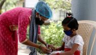 A nurse checks a coronavirus disease patient's pulse before she is admitted into a school turned COVID-19 care facility on the outskirts of Mumbai, India, May 24, 2021. REUTERS/Francis Mascarenhas/File Photo