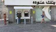 A man uses an ATM at a Bank Audi branch, after banks closed on Tuesday in solidarity with the Lebanese Swiss Bank, in Beirut, Lebanon June 29, 2021. REUTERS/Mohamed Azakir