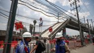 FILE PHOTO: Employees work as part of the investigations in front of the site where an overpass for a metro partially collapsed with train cars on it, in Mexico City, Mexico May 19, 2021. REUTERS/ Henry Romero/File Photo

