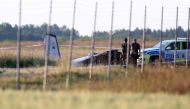 Police officers observe a small aircraft that crashed at Orebro Airport, Orebro, Sweden, July 8 2021. TT News Agency/Jeppe Gustafsson via REUTERS