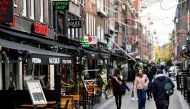 FILE PHOTO: People walk past restaurants and bars as the Netherlands battles to control the spread of the coronavirus disease (COVID-19), in Amsterdam, Netherlands October 14 2020. REUTERS/Piroschka van de Wouw/File Photo/File Photo
