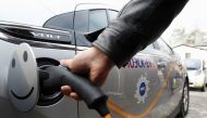 A man charges an electric car during a demonstration ceremony to launch a charging station, owned by the Moscow United Electric Grid Company (MOESK), in Moscow February 28, 2012. REUTERS/Sergei Karpukhin/File Photo