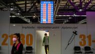 A worker peers out of a door in front of COVID-19 vaccination booths at the Arena Treptow vaccination centre in Berlin, Germany, August 9, 2021. John Macdougall/Pool via Reuters 