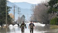 Rob Feenstra and Brendan van Biert walk through flood water after conducting a hazard assessment at a local bio gas plant after rainstorms lashed the western Canadian province of British Columbia, triggering landslides and floods, shutting highways, in Abbottsford, British Columbia, Canada November 22, 2021. REUTERS/Jennifer Gauthier
