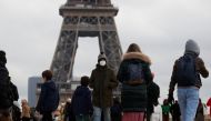 People, wearing protective face masks, walk on Trocadero square near the Eiffel Tower in Paris amid the coronavirus disease (COVID-19) outbreak in France, December 6, 2021. REUTERS/Gonzalo Fuentes
