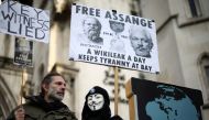 Supporters of Julian Assange hold signs outside the Royal Courts of Justice in London, Britain December 10, 2021. REUTERS/Henry Nicholls