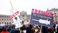 Demonstrators hold flags and placards as they gather to protest against the coronavirus disease (COVID-19) restrictions and the vaccine mandate in front of Hofburg Palace in Vienna, Austria, December 11, 2021. REUTERS.