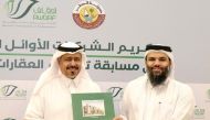 Director of the Department of Endowments, Dr. Sheikh Khalid bin Mohammed bin Ghanem Al Thani honouring representative of a winning firm at a ceremony. 