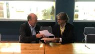Chairman of Sport at the Service of Humanity David Eades and CEO of Save the Dream Massimiliano Montanari exchange documents during the MoU signing ceremony.