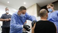 Valeriu Gheorghita, president of the National Committee for Coordination of Vaccination Activities against COVID-19, administers a dose of the coronavirus disease (COVID-19) vaccine to a man during a vaccination marathon, in Bucharest, Romania, October 24, 2021. Inquam Photos/Georg Calin via REUTERS

