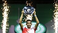 Canada's Felix Auger-Aliassime poses with the trophy as he celebrates after winning the final against Greece's Stefanos Tsitsipas REUTERS/Piroschka Van De Wouw