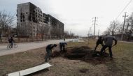 People dig a grave for victims killed during Ukraine-Russia conflict in a street in the besieged southern port city of Mariupol, Ukraine March 20, 2022. REUTERS/Alexander Ermochenko