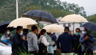People, some of who are believed to be relatives of victims, arrive at the entrance of Lu village near the site where a China Eastern Airlines Boeing 737-800 plane flying from Kunming to Guangzhou crashed, in Wuzhou, Guangxi Zhuang Autonomous Region, China March 23, 2022. REUTERS/Carlos Garcia Rawlins