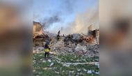 Emergency crew tend to a fire near a burning debris, after a school building was hit as a result of shelling, in the village of Bilohorivka, Luhansk, Ukraine, May 8, 2022. State Emergency Services/Handout via REUTERS