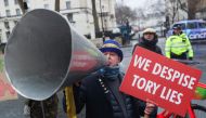 Steve Bray, a British activist, carries a sign and speaks into the megaphone as he participates in a protest against British Prime Minister Boris Johnson in London. (Reuters/May James/File Photo)
 