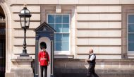 A police officer approaches with a bottle of water to give to a member of the Queen's Guard, during the hot weather, outside Buckingham Palace in London, Britain, July 18, 2022. (REUTERS/John Sibley)