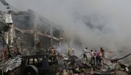 People help firefighters to extinguish a fire after blasts ripped through a fireworks warehouse in a shopping mall in Yerevan, Armenia, August 14, 2022. (Vahram Baghdasaryan/Photolure via REUTERS) 
